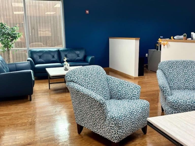 Blueview Recovery waiting area with sofas, patterned chairs, coffee table, and reception desk.