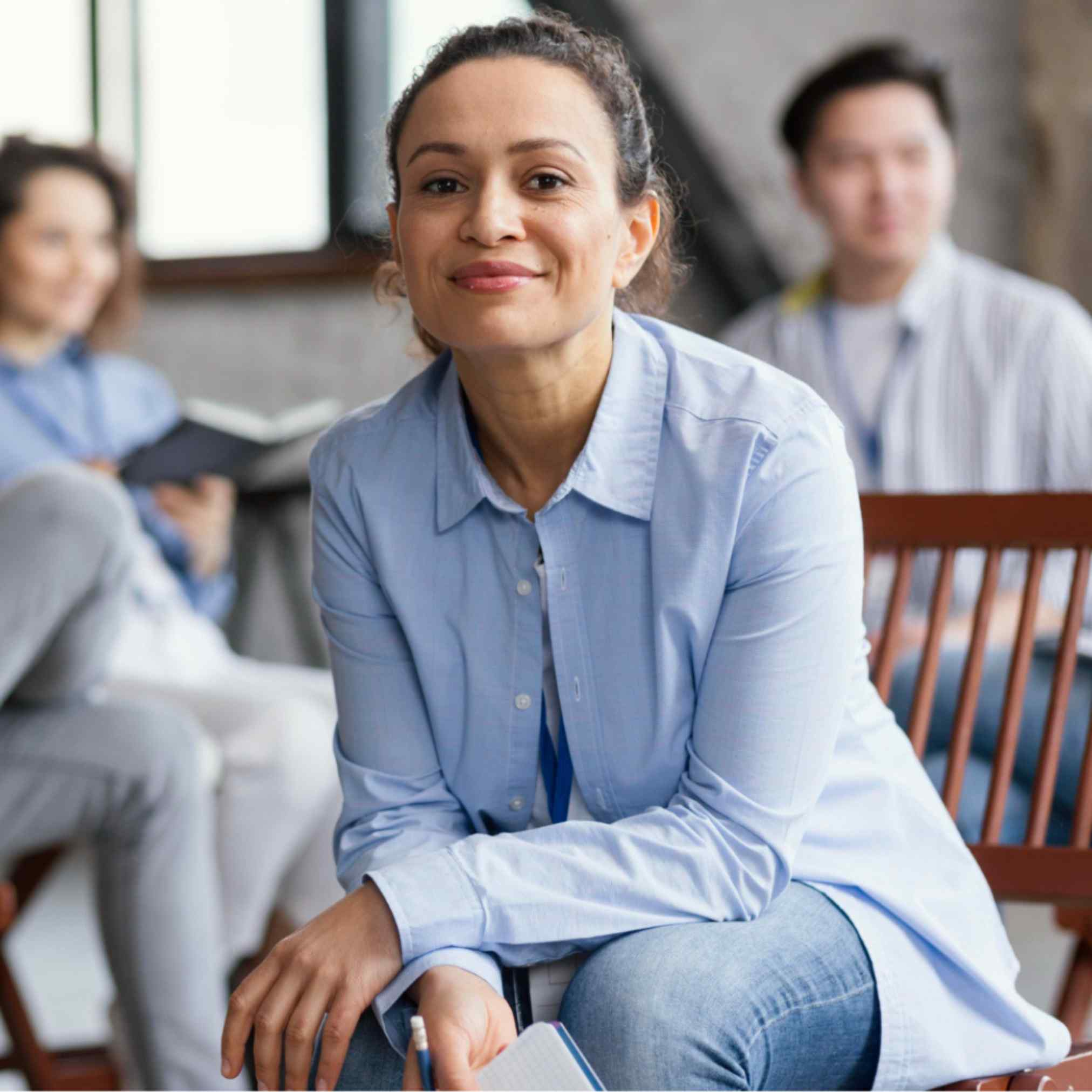 Woman smiling while sitting in a group therapy session