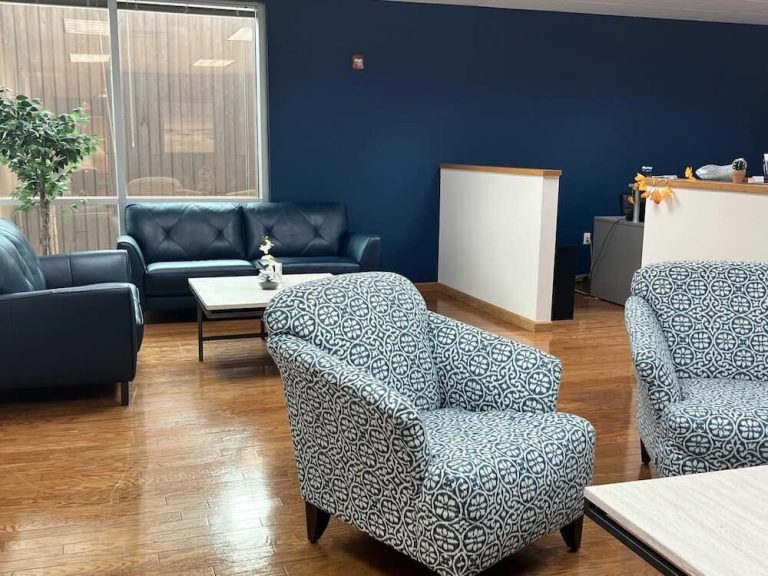 Blueview Recovery waiting area with sofas, patterned chairs, coffee table, and reception desk.