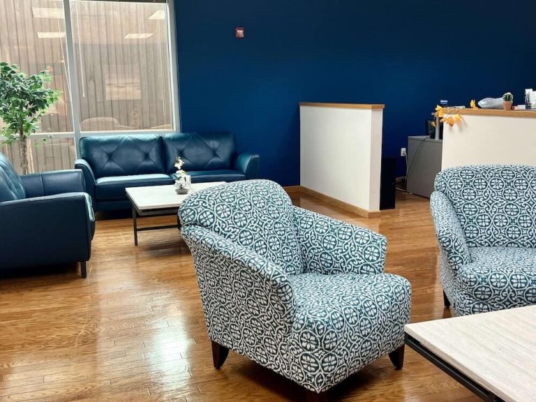 Blueview Recovery waiting area with sofas, patterned chairs, coffee table, and reception desk.