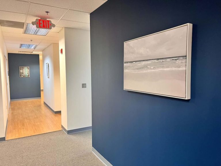 Blueview Recovery hallway with blue accent wall and framed ocean artwork.