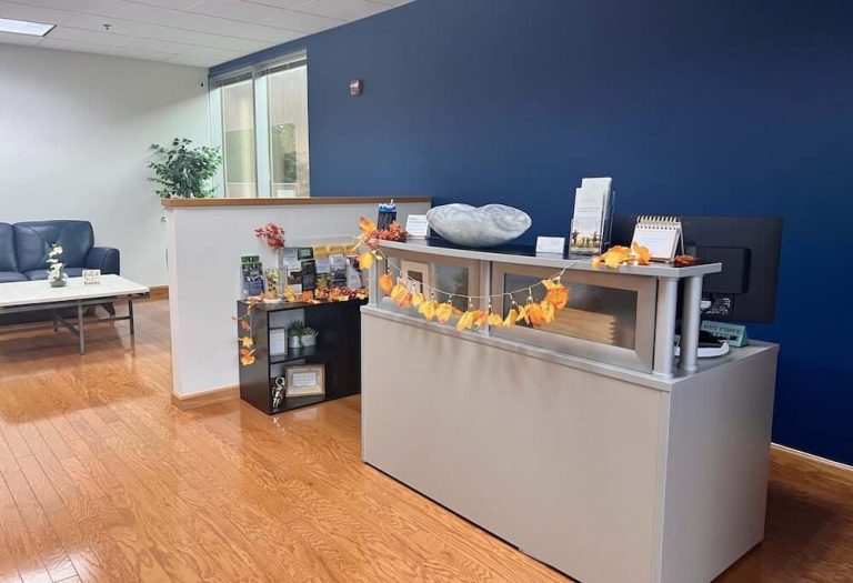 Blueview Recovery front desk with brochures, fall decorations, and nearby waiting area.
