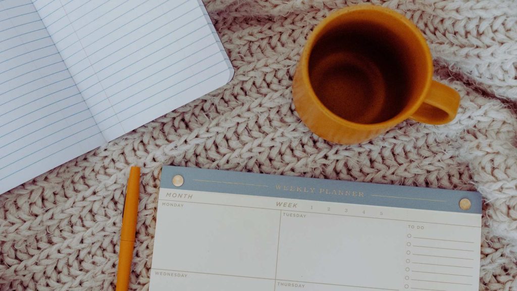 What Are Relapse Prevention Models and How Do They Work? 2 Weekly planner and notebook representing structured relapse prevention models in recovery.