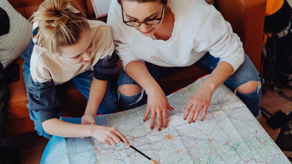 Two women studying a map together, symbolizing creating a personalized relapse prevention plan in addiction treatment.