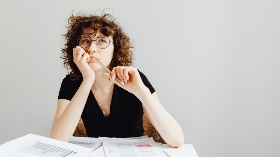 a woman thinking about the Alcohol Use Disorder Criteria.