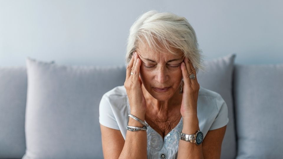 alcoholic dementia hero image of someone holding their head after drinking.